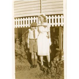 Family photograph from the Quelch Forno collection : Woman and a boy posing for a photograph in the front yard