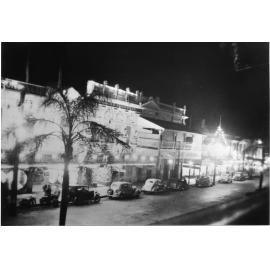 Queensland Hotel and the National Bank, V.P. night, Flinders Street, Townsville, 8.6.1946