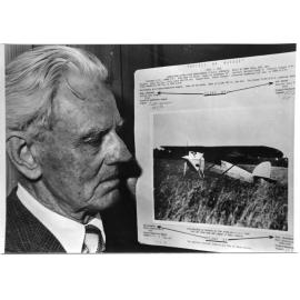 Bob Brown holding a photograph of the ultralight aircraft, "Spirit of Aussie" 1929-1936