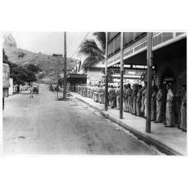 Troops lined up for a beer at a wet canteen in Blackwood Street, Townsville, 9 February 1944