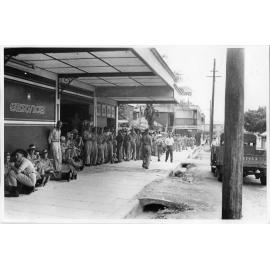 Troops lined up for a beer at a wet canteen in Blackwood Street, Townsville, 9 February 1944