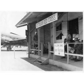 A plane of the 1st Medical Air Evacuation Transport Unit, RAAF, alongside the Australian Red Cross Building at Garbutt Airport on 26th November, 1945
