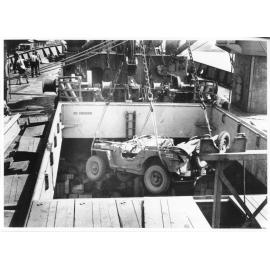 A Jeep belonging to 1st Australian Army Transport being loaded aboard the Liberty Ship SS James Oliver at Townsville, 18 October 1944, for shipment to Lae, New Guinea