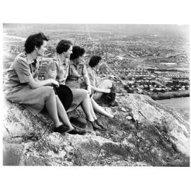Four members of the Australian Women's Army Service sitting on Castle Hill, overlooking West End, Townsville, 2nd April, 1945