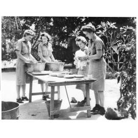 Women from the W.A.A.F. barracks, St. Anne's school, (cnr. Walker and Stokes Streets) wash their dishes after a meal