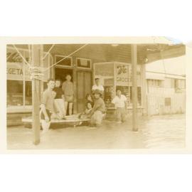 Townsville residents standing in floodwater in front of Philip Leong's store during the 1946 Townsville flood