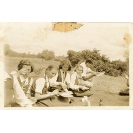 Students and adult eating outdoors