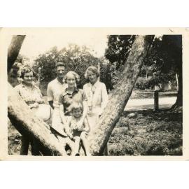Family photograph from the Quelch Forno collection : Four adults and one child posing near a tree for a photograph