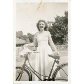 Family photograph from the Quelch Forno collection : Beryl Forno standing beside a bicycle