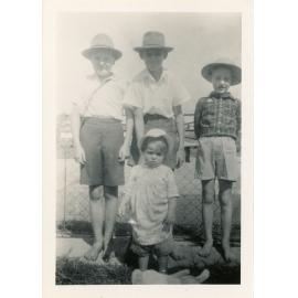 Family photograph from the Quelch Forno collection : Three boys and a small child standing near a fence