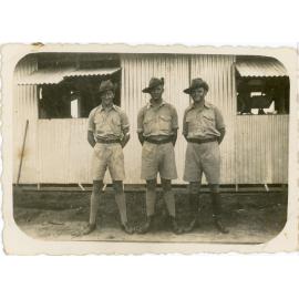 Family photograph from the Quelch Forno collection : Three soldiers in uniform posing for a photograph in front of a hut