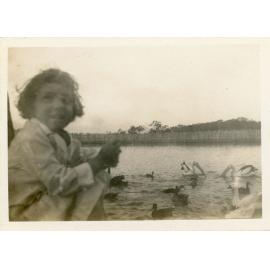 Family photograph from the Quelch Forno collection : Girl posing for photograph with waterbird in the background