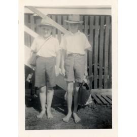 Family photograph from the Quelch Forno collection: Two schoolboys with satchels standing near the steps of a house, Townsville
