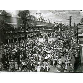 Soldiers and residents gather for the peace announcement, Flinders Street, Townsville, 15 August 1945