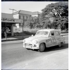 Car 37 in the Redex Trial 1955 on Ingham Road, Townsville. West End Primary School and the Golden Gate cafe are in the background