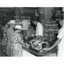 Businessman Philip Leong mans the checkout at his Hermit Park Grocery Store.