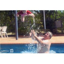 Man and child playing in a swimming pool, n.d.