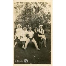 Group posing on a picnic bench, 1934