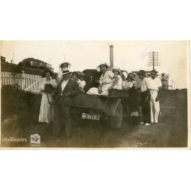 Group sitting in the back of a tractor, 1934