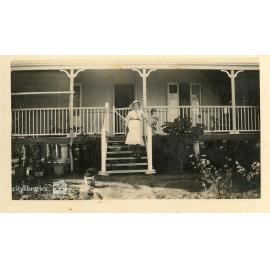 Person on the front steps of a house, 1935