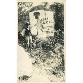 Arthur (Doug) Armstrong standing by artwork on a rock, Helen Blazes, Mayoress of Magnetic, Magnetic Island, [between 1908 and 1930].