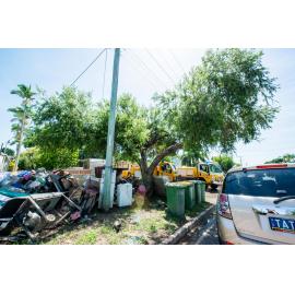 Damaged goods stacked on footpath of flood affected house, SES vehicles in driveways, Hermit Park, 2019