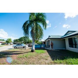 Resident standing in front of flood affected home with skip bin located on driveway, Idalia, 2019