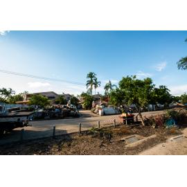 Flooded contents of homes piled up outside of apartment fence, Rosslea, 2019.