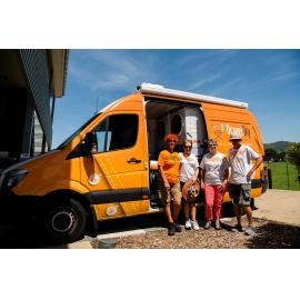 Orange Sky Australia workers/volunteers standing in front of company van outside Townsville Stadium, Murray, 2019.
