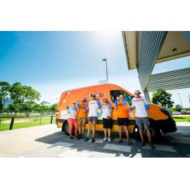 Orange Sky Australia workers/volunteers standing in front of company van outside Townsville Stadium, Murray, 2019.