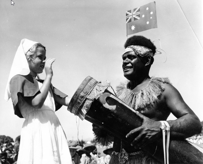 Willie Thaiday with a member of the Giru Junior Red Cross at the civic reception for Queen Elizabeth II and Prince Philip at the Sports Reserve, Townsville, March 1954.